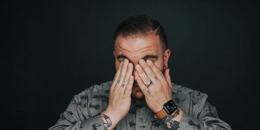 a man touching or tapping his eyes