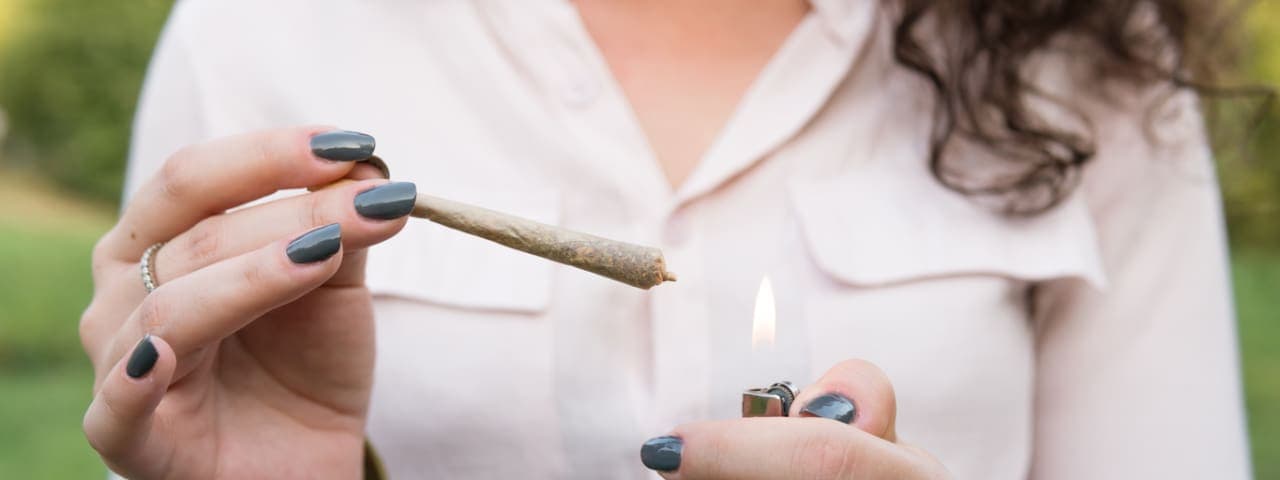 A woman's hands lighting a cannabis pre-roll smoking weed for the first time